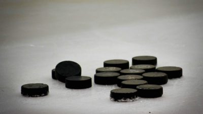 En hög med hockeypuckar en is.
