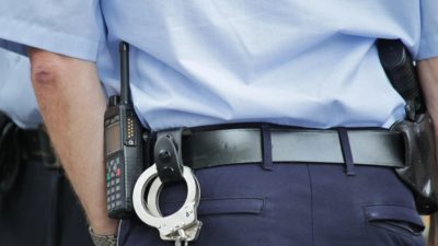 Polis med pistol och handbojor