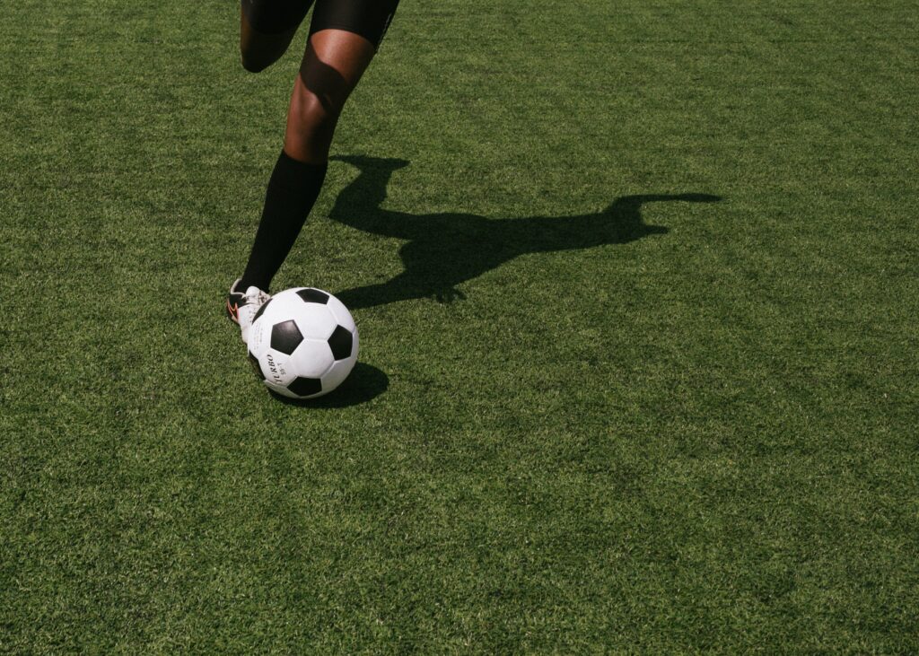 En person som sparkar på en fotboll